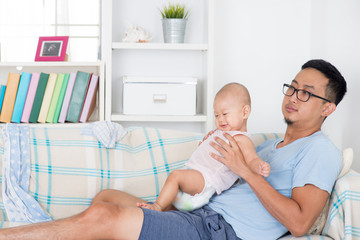 Exhausted father taking care baby alone