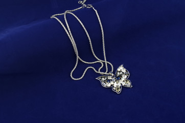 Silver butterfly fashion jewelry with rhinestones on blue velvet background