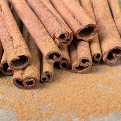  cinnamon sticks on wooden background