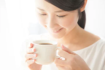 Fotobehang コーヒーを飲む女性　笑顔　窓際 © aijiro