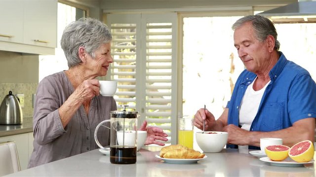 Happy senior couple enjoying breakfast