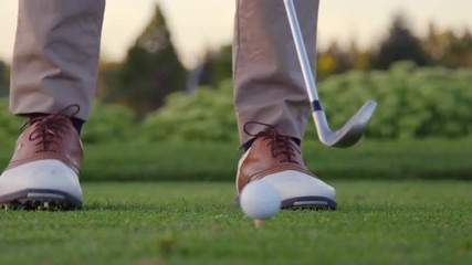 Golfer takes practice swings then hits his ball 