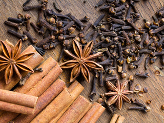 cinnamon sticks, star anise and cloves on wooden background
