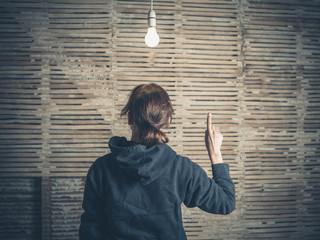 Young woman having idea under light bulb