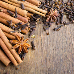 cinnamon sticks, star anise and cloves on wooden background