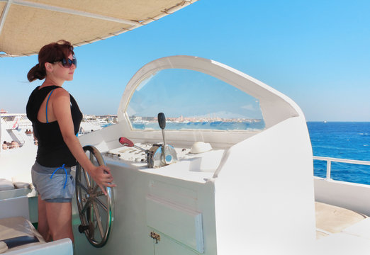 woman at the helm of yacht captain