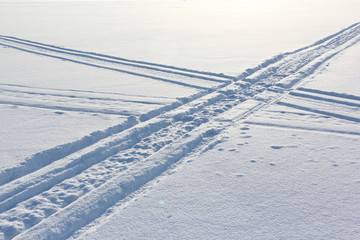 Traces from a snowmobile on a snow surface of the river