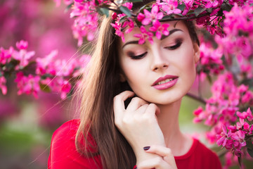 Naklejka premium Happy beautiful young woman in spring blossom park. 