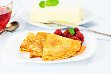 Russian pancakes with black tea and strawberries.
