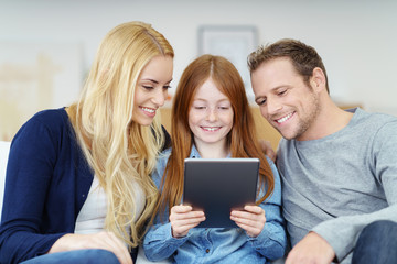 familie schaut gemeinsam auf tablet