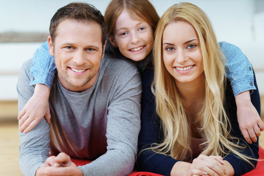 glückliche junge familie liegt auf dem fußboden im wohnzimmer