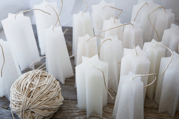 white candles workpiece and a coil of wicks on old wooden backgr