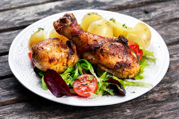 Baked chicken legs with potatoes and vegetables