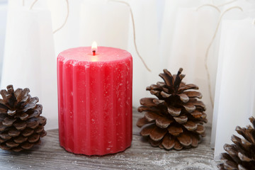 red rippled candle among white blanks candles