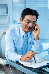 Smiling asian businessman calling someone