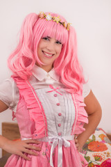 young girl in a bedroom in a pink cute dress