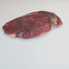 raw duck breast inserted in curing salt and spices ready to burn