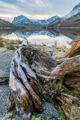 Buttermere shoreline leading line into beautiful clear reflections of High Stile at Buttermere in...