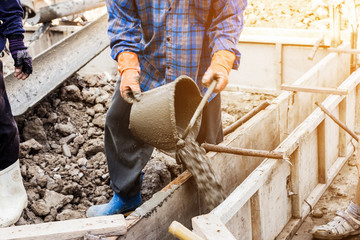 worker mixing cement mortar plaster for construction with vintag