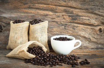 white coffee cup and coffee bean on wood background