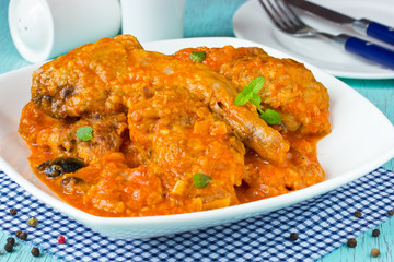 Rabbit meat in tomato sauce with black olives at Greek style. Diet food, traditional cuisine of Greece