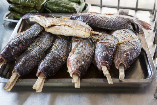 Whole fish marinated ready for baking. In the mouth have fish sticks.