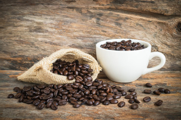 white coffee cup and coffee bean on wood background