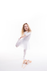 Fototapeta na wymiar Flexible little girl ballerina doing gymnastic exercises.