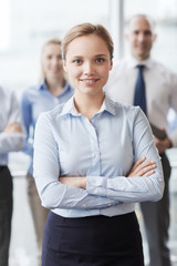 smiling businesswoman with colleagues in office