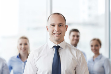 smiling businessman with colleagues in office