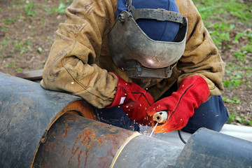 Welder in Action/ Spark, Man in protective suit with helmet