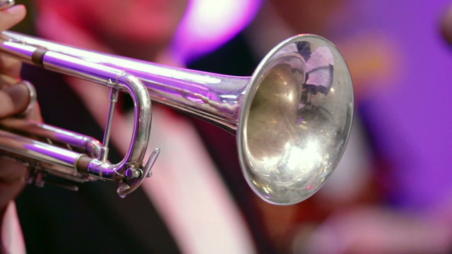 Man playing a silver trumpet in a band.