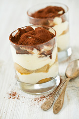 tiramisu in glass on wooden surface