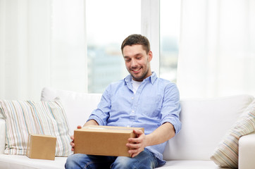 happy man with cardboard boxes or parcels at home