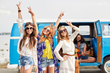 happy hippie friends having fun over minivan car