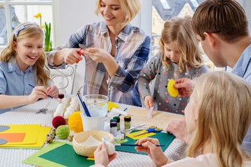 Cheerful family having fun painting and decorating easter eggs.