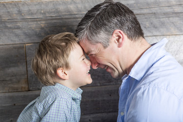 Young father with son in studio wood background