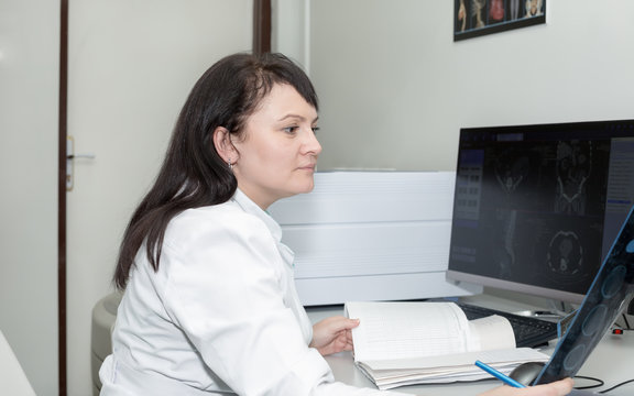 Brunette female doctor examining an CT scanner results