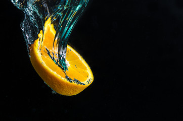 Orangenscheibe fällt in Wasser