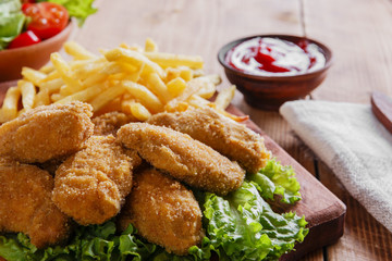 chicken wings fried in breadcrumbs with sauce  and french fries