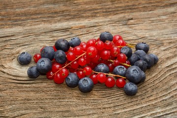 red currant and blueberries on old wooden table