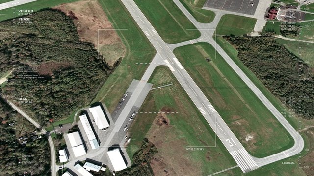 Aerial surveillance flyover of a small airport's main runway and taxiway. Reversible loop. 
