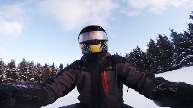 Closeup of a Fast Snowmobile Driver in Forest