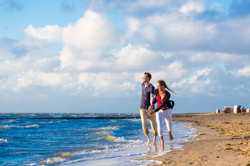 Paar genießt romantischen Sonnenuntergang am Nordsee Strand 