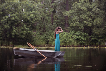 Fototapeta na wymiar long hair brunette in a dress standing on the boat