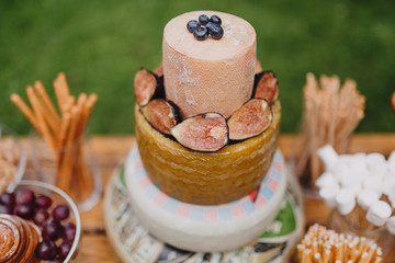 cheese bar on a wooden table on a background of green grass
