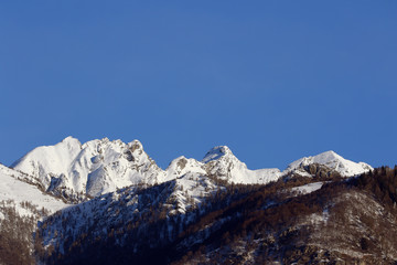 Mountain peaks and valley covered in snow with clear blue skies