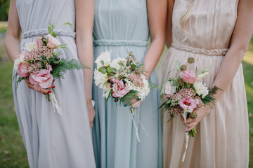 bridesmaid dresses in pastel are holding bouquets in a rustic st - obrazy, fototapety, plakaty