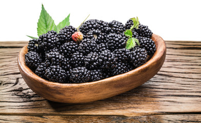 Blackberries in the wooden bowl. White background.