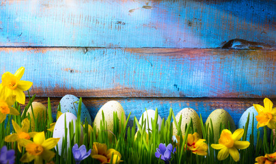 art Easter Background with easter eggs and spring flowers on gre